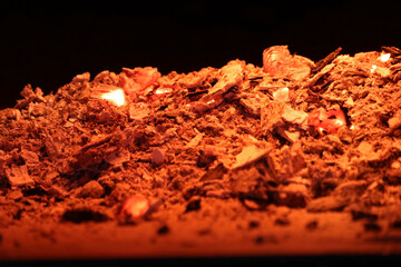 Red-hot charcoal and ash on a black background. Selective focus.