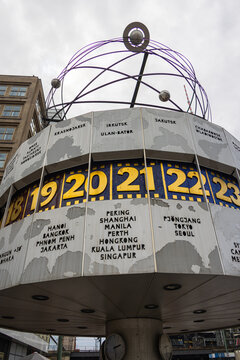 Berlin, Germany - June 29, 2022: World clock at Alexanderplatz near the TV tower. In the times of the GDR, city center of East Berlin. World time clock shows the time of Singapore and Kuala Lumpur