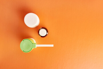 Throat spray and liquid medicine on orange background. Treatment and prevention of diseases.