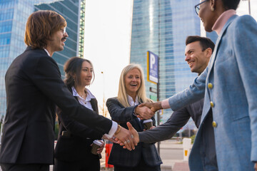 Group of multi-ethnic business people in a business park introducing themselves and shaking hands outdoors