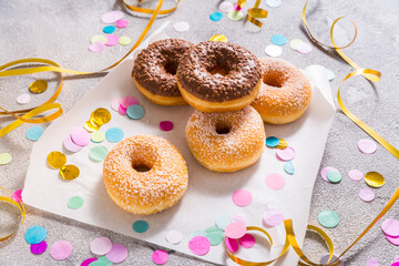 Krapfen, berliner or donuts with streamers, confetti  for carnival or party