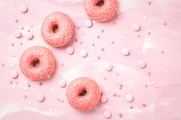 Pink donuts with sprinkles on pink background