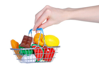 Hand holding toy fruits and vegetables in shopping grocery basket on white background isolation