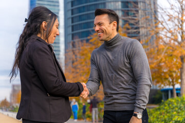 Multi-ethnic businessman and businesswoman, greeting by shaking hands, good work environment
