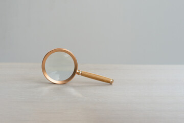 Information search, investigation, counterfeit identification and crime world review and study magnifying glass on wooden table Search and analysis, analysis and detailed study.