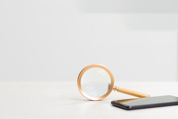 Woman research online shop.Magnifying glass with mobile phone and gift box on shopping cart.