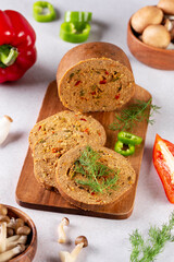 Mushroom based vegan sausage with vegetables and spices on wooden board, top view