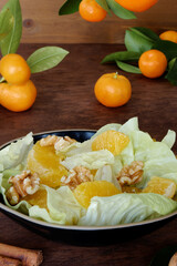 Orange salad with orange fruit, romaine lettuce and walnut nuts. Fresh, homemade salad.