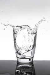 Drinking water splashing out of the glass.