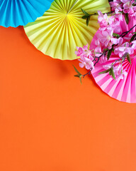 Chinese or lunar new year flat lay with paper decorations, mandarins and flowers on orange