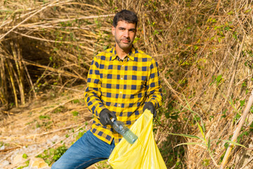 Naklejka na ściany i meble Portrait of man collecting garbage in a forest. Ecology, clean nature from plastics