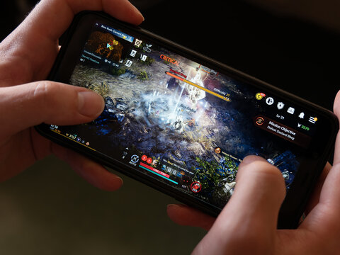 Cork, Ireland, July 31, 2022. A android smartphone in the hands of a white man. Playing mobile MMORPG Black Desert Mobile. A Korean mobile game on a smartphone screen, illustrative editorial.