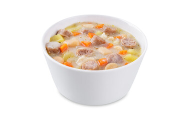 Potato carrot white bean soup with meat sausages in a bowl on a white isolated background