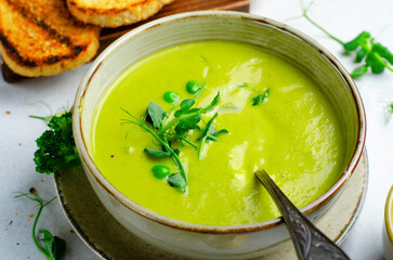 Pea Soup with Green Vegetables, Broccoli and Pea Sprounts with cheese on bright backround