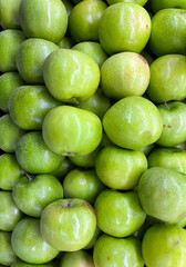 Green apples displayed at a market stand
