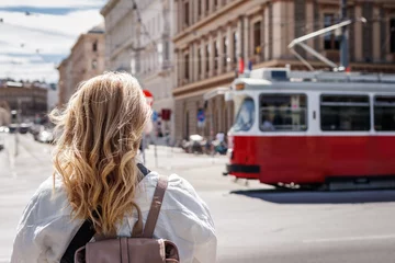 Photo sur Aluminium Vienne Woman looking at passing tram in Vienna. Tramway public transportation