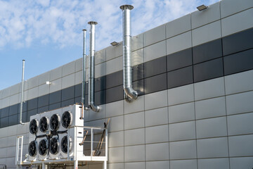 Large ventilation pipes on facade of commercial building. Outdoor split air conditioner units...