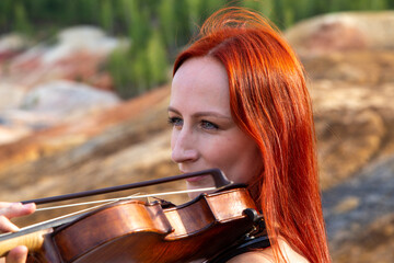 a red-haired violinist on the background of a Martian landscape is a large portrait with a...