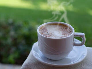 Cup of coffee on white tablecloth in the garden