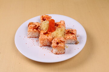 Aburi spicy sushi salmon with crispy chips on topping placed on brown background