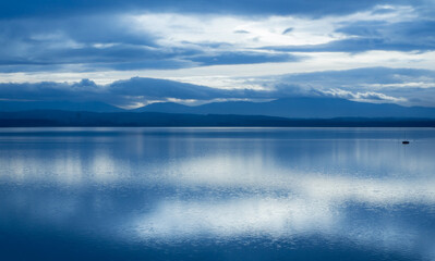 Lonely boat on a lake with mountains in the background