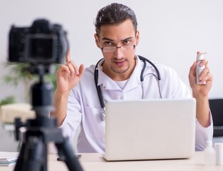 Young male doctor recording video for his blog