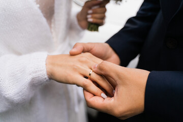 Obraz premium the groom puts on the ring to the bride, close-up