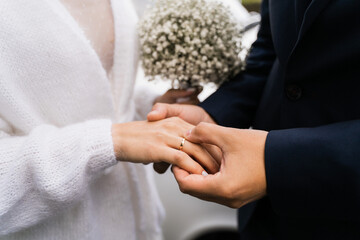 the groom puts on the ring to the bride, close-up