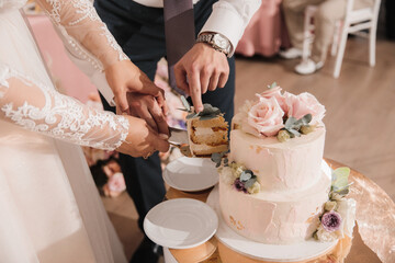 Newlyweds cut the first piece of wedding cake at their wedding