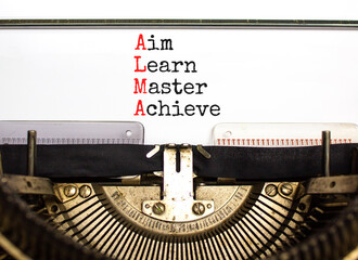 ALMA aim learn master achieve symbol. Concept words ALMA aim learn master achieve typed on retro typewriter on beautiful white background. Business ALMA aim learn master achieve concept. Copy space.