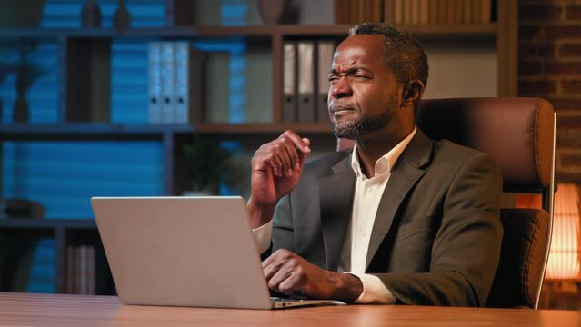 Concentrated businessman typing on laptop pensive thoughtful man thinking deep in thoughts ponders looking for solution feeling inspired comes up with idea eureka raises index finger up remembering