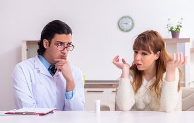 Young female patient discussing with male psychologist personal