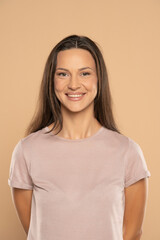 Fototapeta premium portrait of young smiling woman on beige background