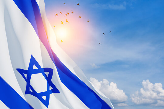 Israel flag with a star of David over cloudy sky background with flying birds. Patriotic concept about Israel with national state symbols. Banner with place for text.