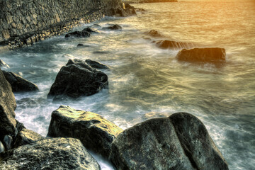 waves over rocks at sunset on the bay of biscay beach in spain