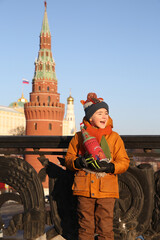 Russian tourist child, cute kid, boy on Red Square. Tower of Kremlin in Moscow city, Russia. Kremlin in Moscow, Russia. Moscow landmark, Russian monument. Moscow Kremlin. New Year, winter in Russia