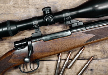 A gun with an optical sight, a hunting on a wooden background.Top view.