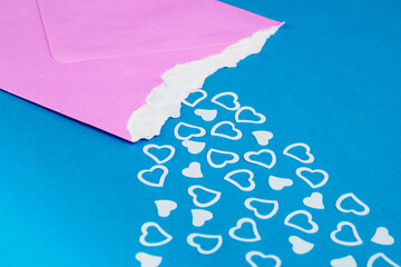 valentines hearts falling out of pink yellow envelope on background