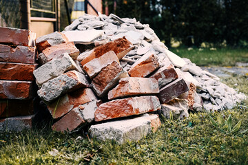 A pile of bricks, stones and rubble from construction intended for disposal, a black dump