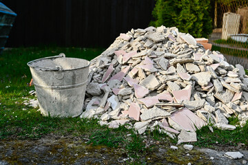 A pile of bricks, stones and rubble from construction intended for disposal, a black dump