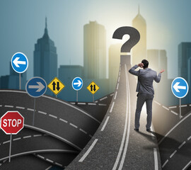 Businessman in uncertainty concept on road intersection crossroa