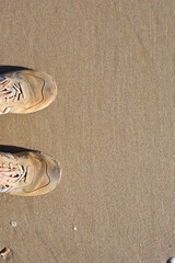 Background created from the sand on the beach with the sneakers.