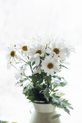 a bouquet of white daisies close-up by the window against the backdrop of snow