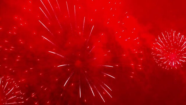 Colorful fireworks festival. Beautiful red fireworks close-up view in slow motion. Wonderful real fireworks in the night sky shot with a telephoto lens. fireworks show. 4K slow motion video.