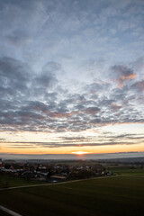 sunrise with colorful clouds above Dürrenmettstetten village in swabia germany with haze in the background