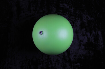 geometric green balloon ball on black background