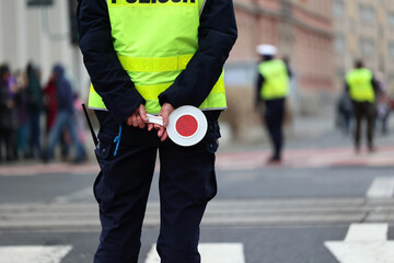 Policjantka ruchu drogowego z lizakiem podczas zatrzymania pojazdów na drodze z tarczą do zatrzymywania.  - obrazy, fototapety, plakaty