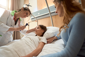 Obraz premium Doctor holds otoscope in his hands to examine patient ear canal