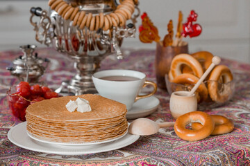 Russian traditions. Russian holiday Maslenitsa. Still life with a cup of tea, a stack of pancakes,...