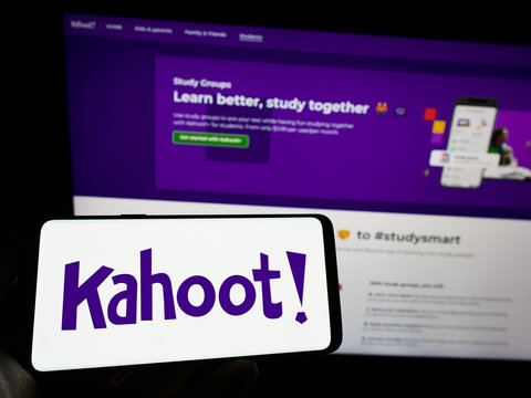 Stuttgart, Germany - 01-01-2023: Person holding mobile phone with logo of Norwegian e-learning company Kahoot on screen in front of business web page. Focus on phone display.
